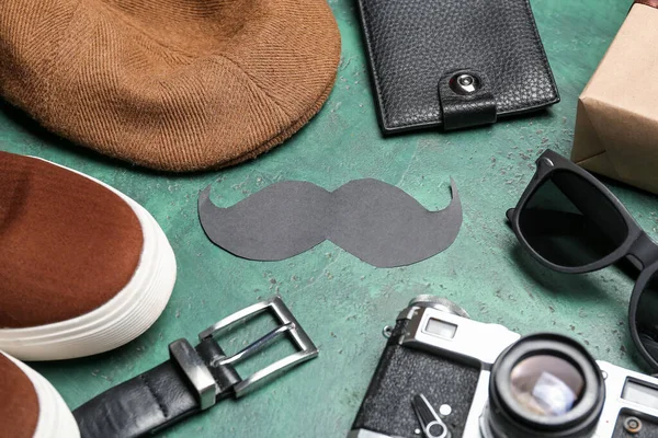 Composition with paper mustache, male accessories and photo camera on color background, closeup. Father's Day celebration