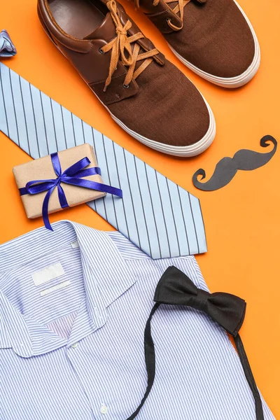 Composition with male shoes, shirt, accessories and gift for Father\'s Day celebration on color background, closeup