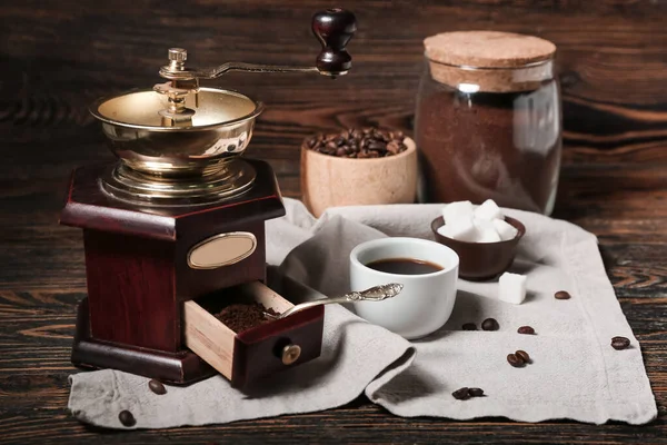 Kaffeemühle Mit Pulver Und Tasse Auf Holztisch — Stockfoto