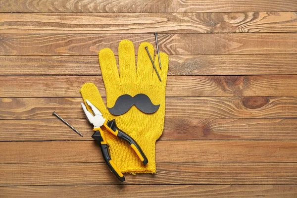 Schnurrbart Aus Papier Mit Handschuhen Zangen Und Nägeln Auf Holzgrund — Stockfoto
