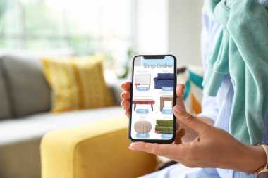 Cep telefonlu bir kadın evden yeni mobilya alıyor.