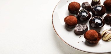 Açık arkaplanda lezzetli çikolata şekerli tabak ve metin için yer