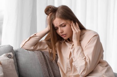 Evde gürültüden rahatsız olan genç bir kadın.