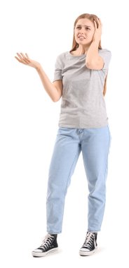 Irritated young woman suffering from loud noise on white background