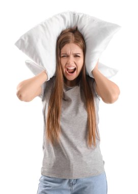 Beyaz arka planda gürültüden rahatsız olmuş, yastıklı genç bir kadın.