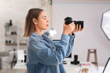 Stüdyoda profesyonel fotoğraf makinesi olan kadın fotoğrafçı.