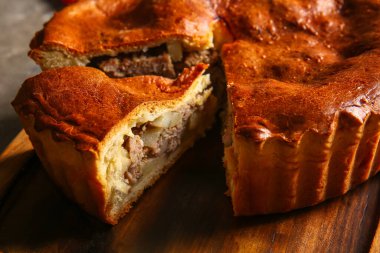 Gri grunge masasında lezzetli etli turta.