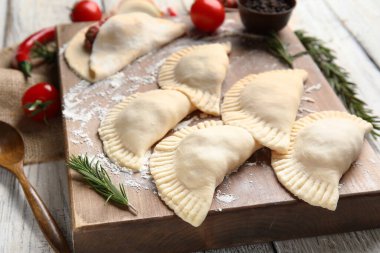 Çiğ et börekleri ve hafif ahşap arka planda malzemeleri olan pano, yakın plan.