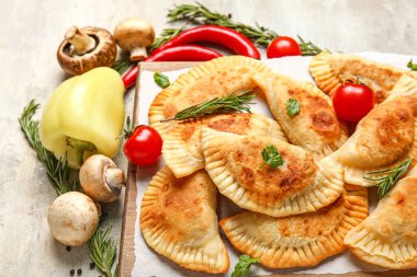 Lezzetli et börekleri, sebzeler ve arkaplanda bitkiler, yakın plan.