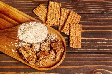 Lezzetli kozinaki ve ahşap zemin üzerinde susam tohumları olan tahta.