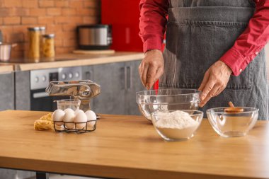 Makarna için hamur yapan adam mutfaktaki masada, yakın plan.