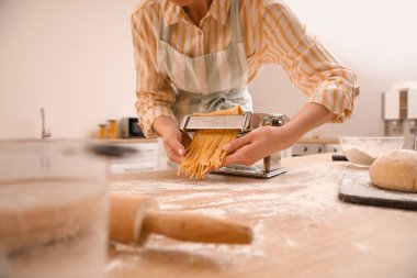 Mutfakta makineyle makarna yapan kadın, yakın plan.