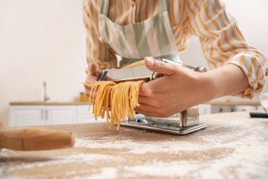 Mutfakta makineyle makarna yapan kadın, yakın plan.