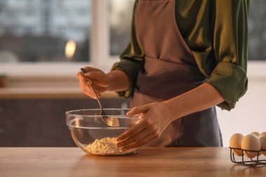 Mutfaktaki masada makarna için hamur yapan kadın, yakın plan.