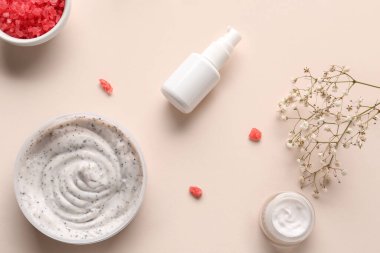 Renkli arka planda vücut fırçası kavanozu, kozmetik ürünleri ve çigila çiçekleri olan kompozisyon