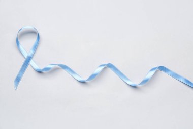 Açık arkaplanda mavi saten kurdele. Prostat kanseri kavramı