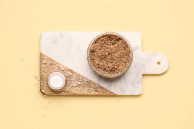 Renk arka planında vücut fırçası, krema ve deniz tuzu olan tahta