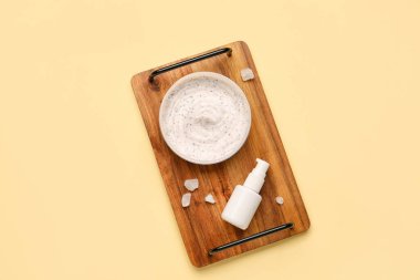 Tahta tahta tahta tahta, arka planda vücut ovalama kavanozu ve kozmetik ürünü var.