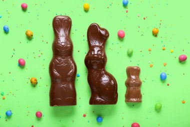 Çikolatalı Paskalya tavşanı. Yeşil arka planda şekerleme ve şekerleme var.