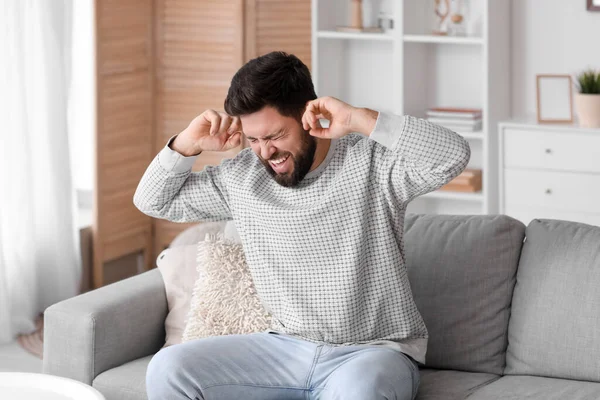 stock image Angry young man suffering from loud noise at home