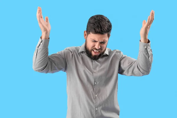 Stressed Young Man Suffering Loud Noise Blue Background — Stock Photo, Image