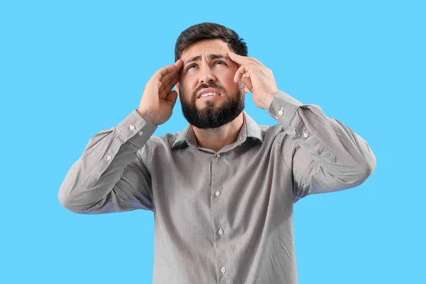 Young Man Suffering Loud Noise Blue Background — Stockfoto
