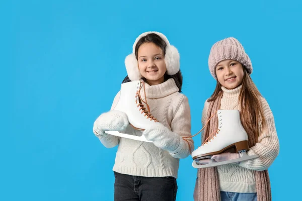 Mavi Arka Planda Buz Pateni Yapan Kışlık Elbiseli Küçük Kızlar — Stok fotoğraf