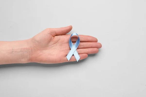 女性的手 蓝色的意识带白色背景 前列腺癌概念 — 图库照片