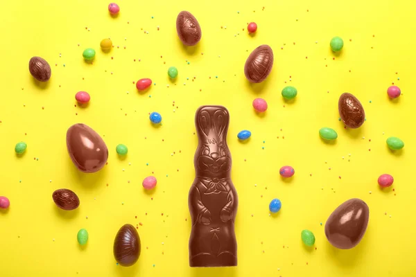 チョコレートイースターバニーの卵と黄色の背景にスプリンクル — ストック写真