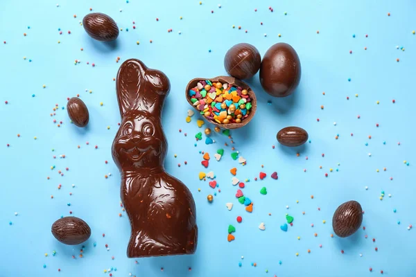 チョコレートイースターバニー卵と青の背景にスプリンクル — ストック写真