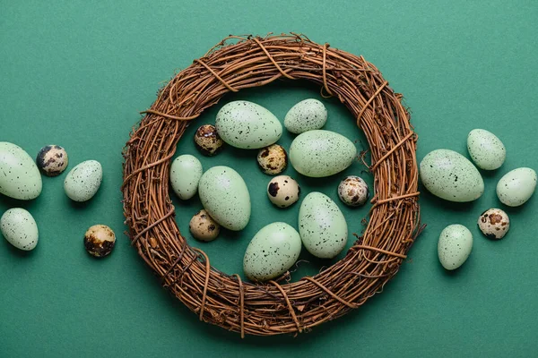 stock image Wreath with Easter eggs on green background