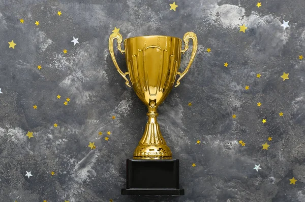 Gold cup with stars on dark background