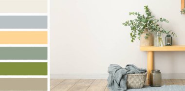 Yeşil okaliptüs dallı vazolar ve ışık duvarının yanında ekoseli sepet. Farklı renk desenleri