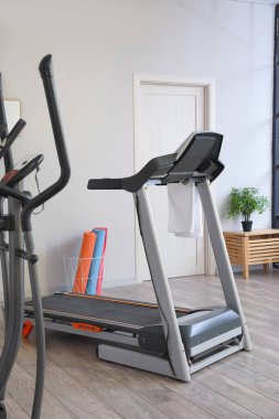 Interior of gym with modern treadmill and sport equipment