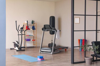 Interior of gym with modern treadmill and sport equipment