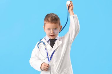 Cute little doctor with stethoscope on blue background
