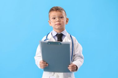 Mavi arka planda panosu olan sevimli küçük bir doktor.