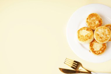 Renkli arkaplanda lezzetli süzme peynirli krep tabağı.