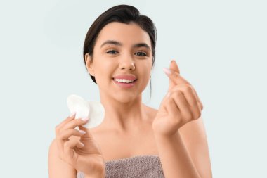 Pamuk yastıklı genç bir kadın hafif arka planda kalp yapıyor, yakın plan.