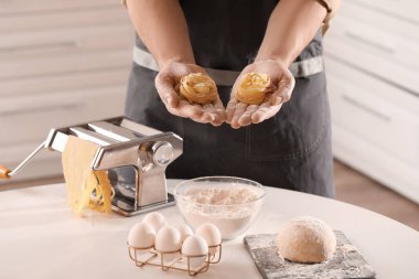 Mutfakta çiğ tagliatelle makarnası olan adam, yakın plan.