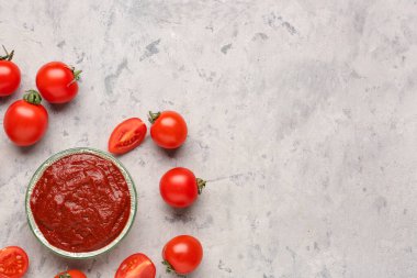 Gri arkaplanda bir kase lezzetli domates ezmesi.