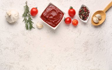 Lezzetli domates ezmesi, sarımsak, biber ve biberiye karışımı beyaz grunge arka planda.