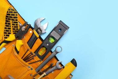 Kemerde pense ve mavi arka planda araçlar