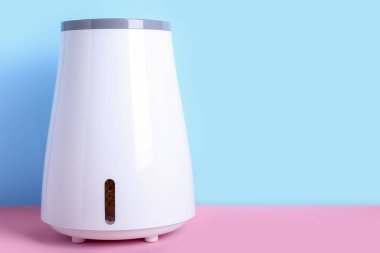 Modern nemlendirici mavi duvarın yanındaki masada.