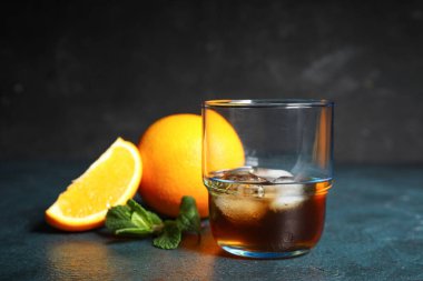 Bir bardak buzlu rom ve koyu arkaplanda limon.