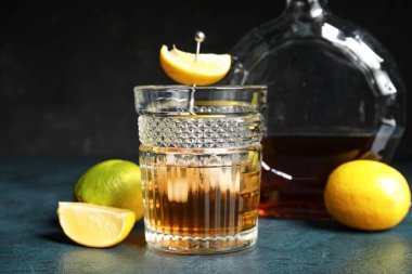 Bir bardak buzlu rom ve koyu arkaplanda limon.