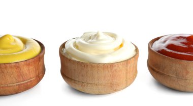 Beyaz arka planda izole edilmiş farklı soslu kaseler, yakın plan.