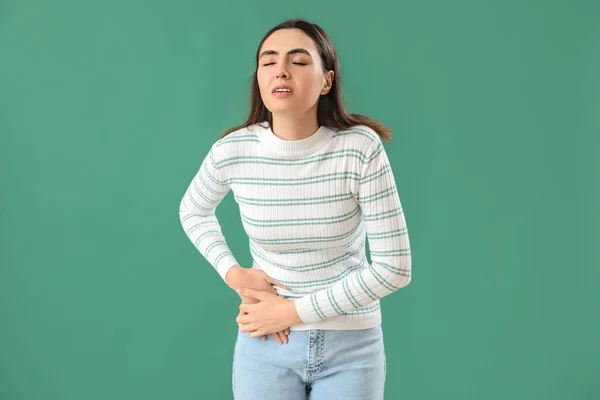 緑の背景に虫垂炎の若い女性 — ストック写真