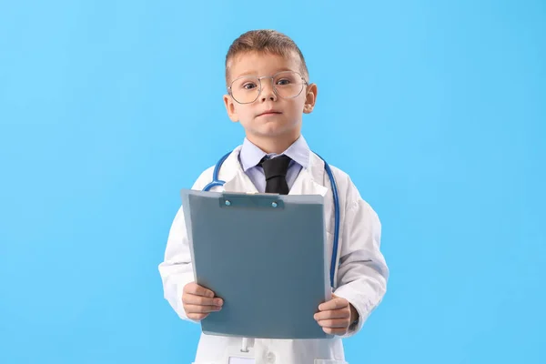 Netter Kleiner Arzt Mit Klemmbrett Auf Blauem Hintergrund — Stockfoto