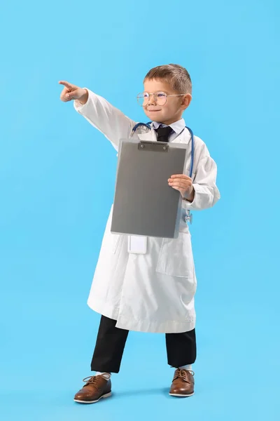 Aranyos Kis Orvos Vágólappal Mutat Valamit Kék Háttér — Stock Fotó